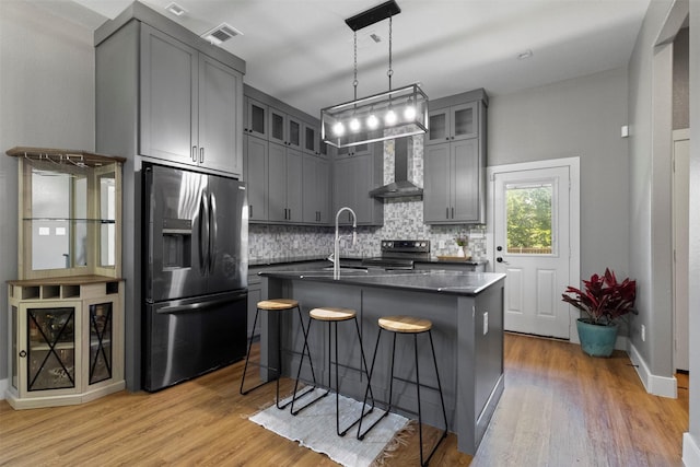408 Bethlehem St, Terrell, TX 75160 - kitchen with appliances with stainless steel finishes, gray cabinets, dark countertops, light wood finished floors, and decorative backsplash