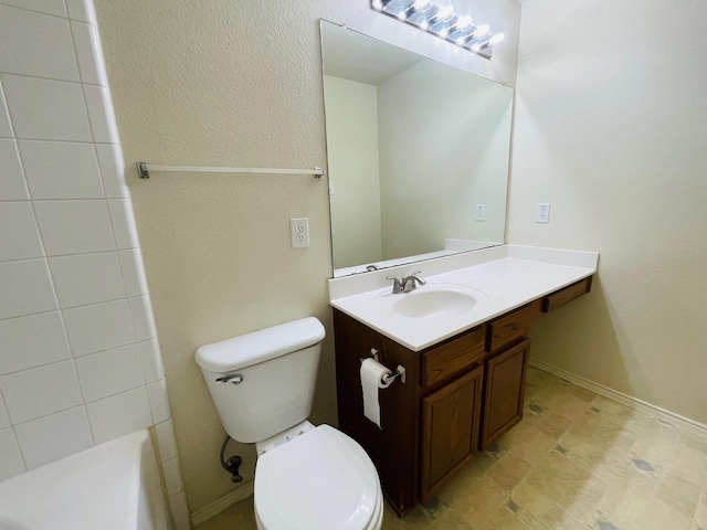 bathroom featuring toilet, walk in shower, stone finish floor, and vanity