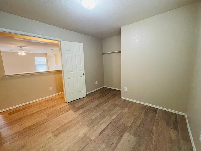 spare room with baseboards, ceiling fan, and wood finished floors