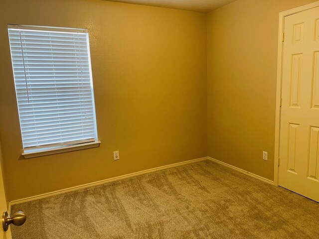 carpeted spare room with baseboards