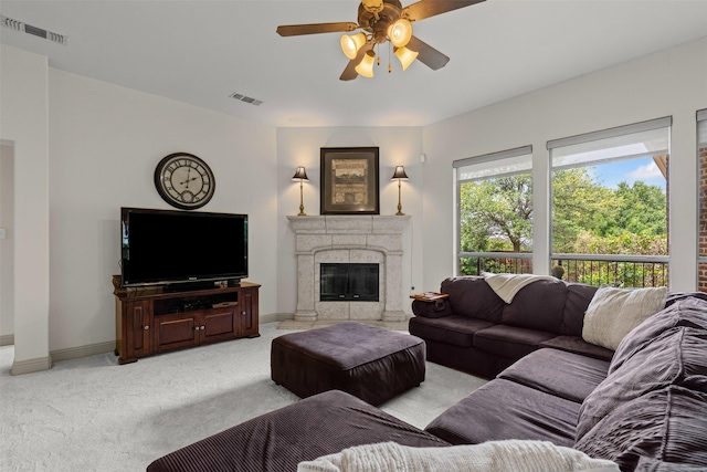 living area featuring baseboards, ceiling fan, light colored carpet, and visible vents