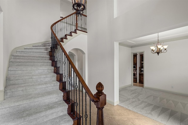stairs featuring carpet floors, baseboards, tile patterned floors, and a chandelier
