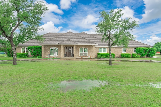 ranch-style house with a tiled roof and a front lawn