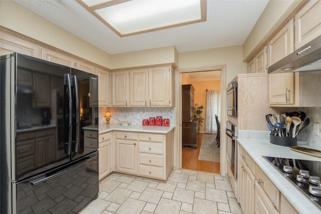kitchen featuring light countertops, decorative backsplash, black appliances, and light brown cabinets