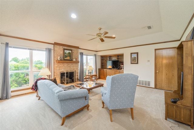 living area featuring visible vents, a ceiling fan, a fireplace, and light carpet