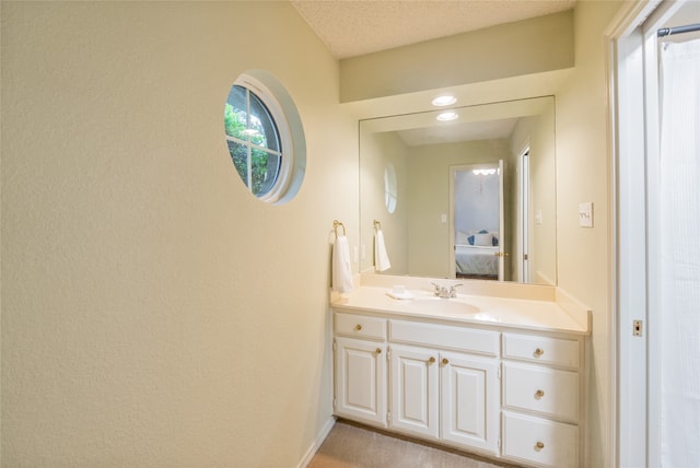 bathroom featuring vanity, baseboards, and ensuite bathroom