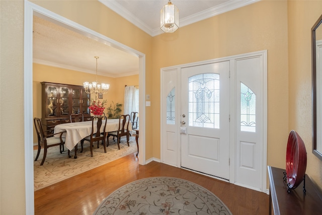 foyer featuring an inviting chandelier, ornamental molding, and dark wood-style floors
