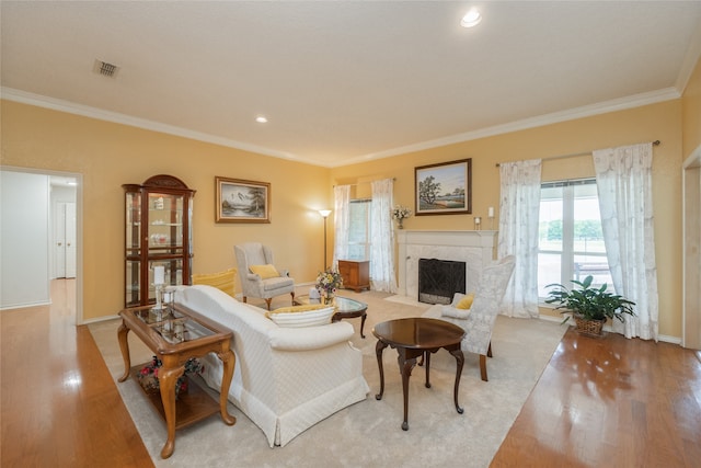 living room featuring visible vents, ornamental molding, wood finished floors, baseboards, and a high end fireplace