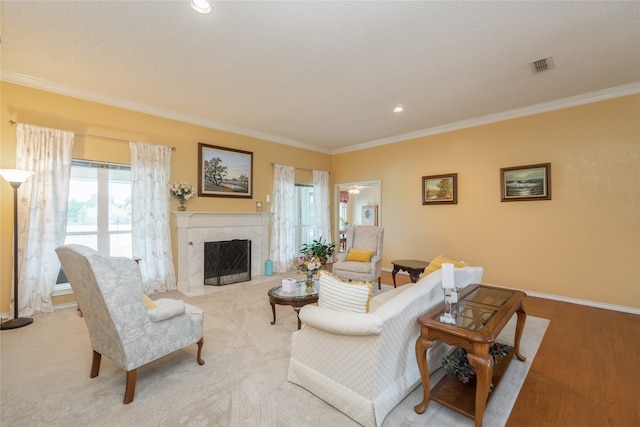 carpeted living area featuring baseboards, visible vents, ornamental molding, and a fireplace
