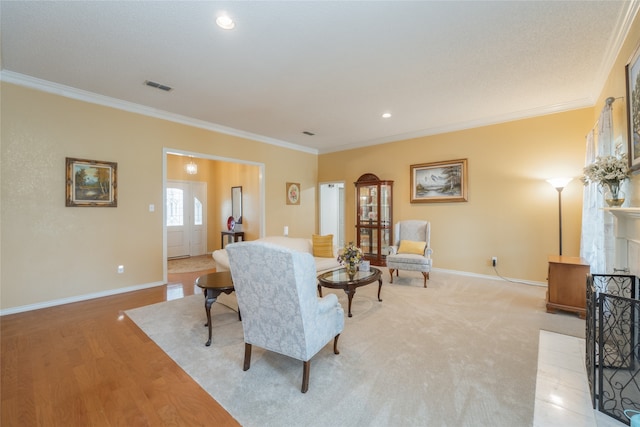 living room with visible vents, light wood-style flooring, baseboards, and crown molding