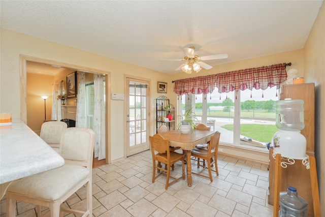 dining space with a ceiling fan and stone finish flooring