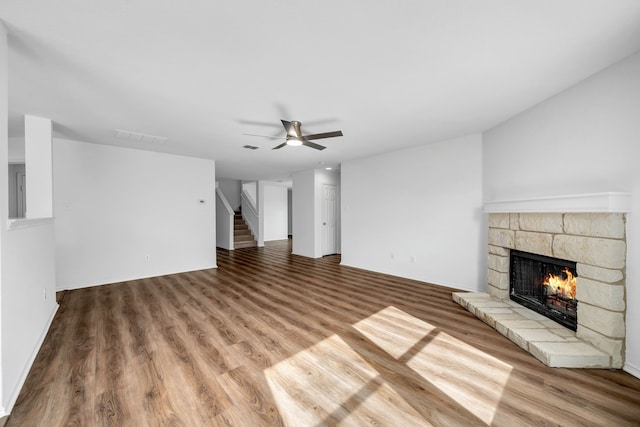 13029 Guerin Dr, Frisco, TX 75035 - unfurnished living room with visible vents, wood finished floors, a fireplace, and stairway