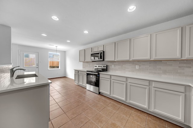 13029 Guerin Dr, Frisco, TX 75035 - kitchen featuring light tile patterned flooring, appliances with stainless steel finishes, decorative backsplash, and a sink