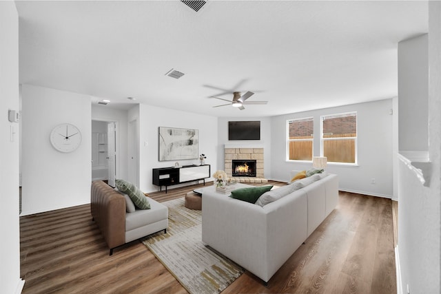 13029 Guerin Dr, Frisco, TX 75035 - living area with visible vents, ceiling fan, wood finished floors, and a stone fireplace