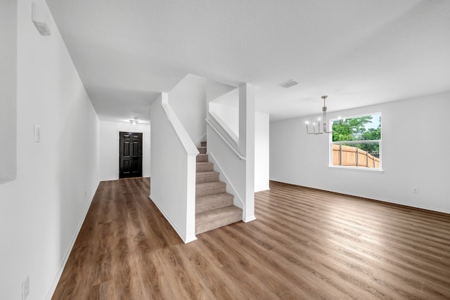 13029 Guerin Dr, Frisco, TX 75035 - unfurnished living room with visible vents, wood finished floors, stairway, baseboards, and a notable chandelier