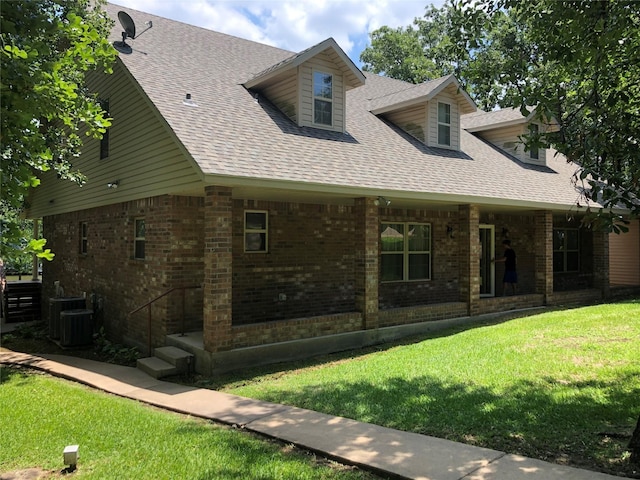 exterior space featuring brick siding, roof with shingles, and a front lawn