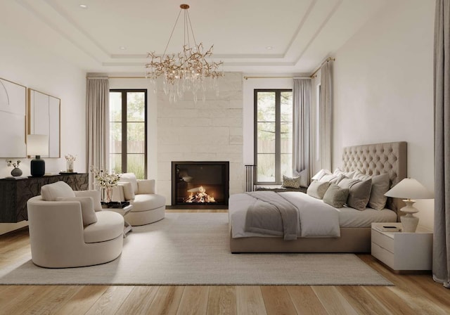 bedroom with a tray ceiling, multiple windows, and a fireplace