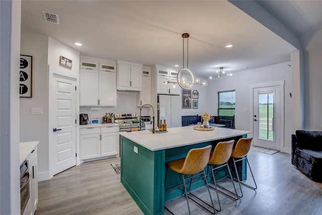 kitchen with light wood-style floors, light countertops, white cabinets, and white refrigerator