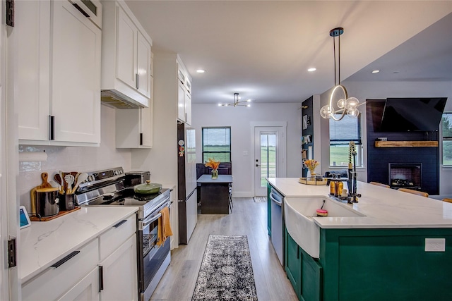 kitchen featuring white cabinetry, appliances with stainless steel finishes, and a notable chandelier