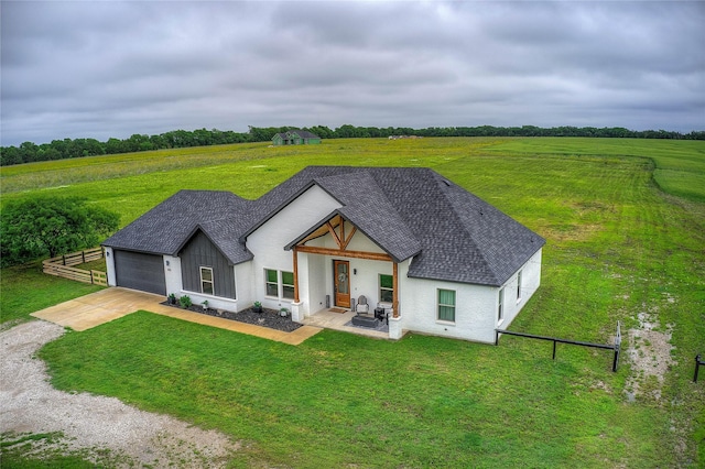 back of property featuring concrete driveway, a yard, fence, and roof with shingles