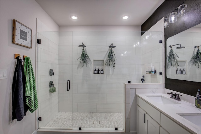 bathroom with double vanity, recessed lighting, a sink, and a stall shower