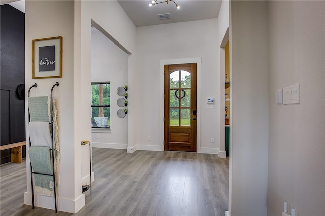 entryway featuring baseboards, visible vents, a healthy amount of sunlight, and wood finished floors