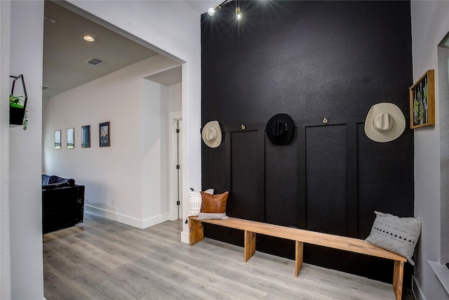 interior space with baseboards, light wood-style flooring, and visible vents