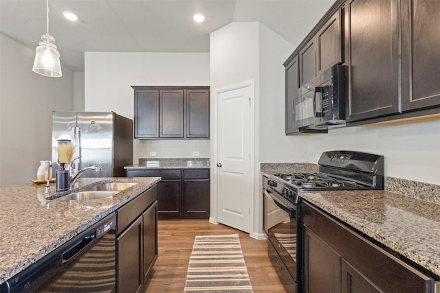 1421 Avalon Ct, Celina, TX 75009 - kitchen with black appliances, light wood-style floors, a sink, dark brown cabinetry, and light stone countertops
