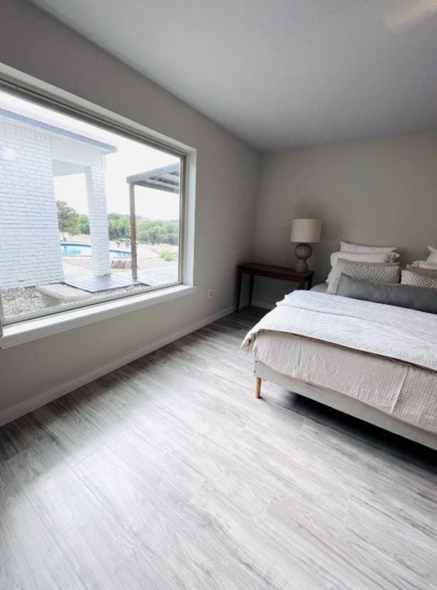 bedroom with baseboards and wood finished floors