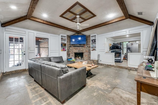 living room with visible vents, a fireplace, ceiling fan, built in shelves, and concrete floors