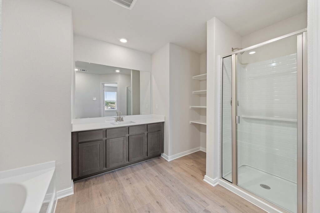 1416 Reiner Dr, Crandall, TX 75114 - bathroom featuring visible vents, a shower stall, wood finished floors, vanity, and baseboards
