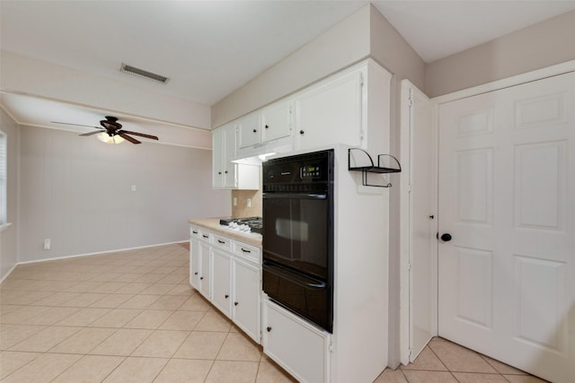kitchen with oven, light tile patterned flooring, a ceiling fan, visible vents, and a warming drawer