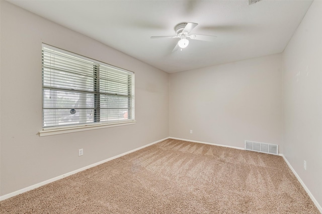unfurnished room featuring ceiling fan, visible vents, baseboards, and carpet