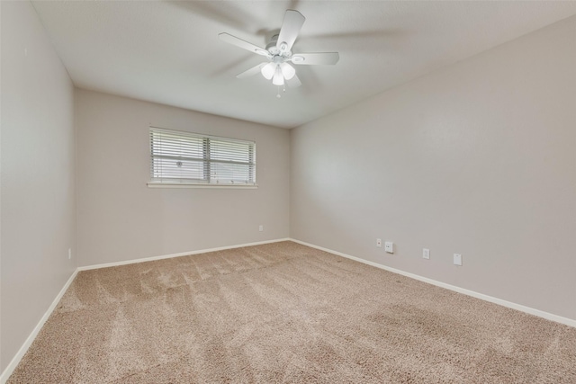 carpeted spare room with ceiling fan and baseboards