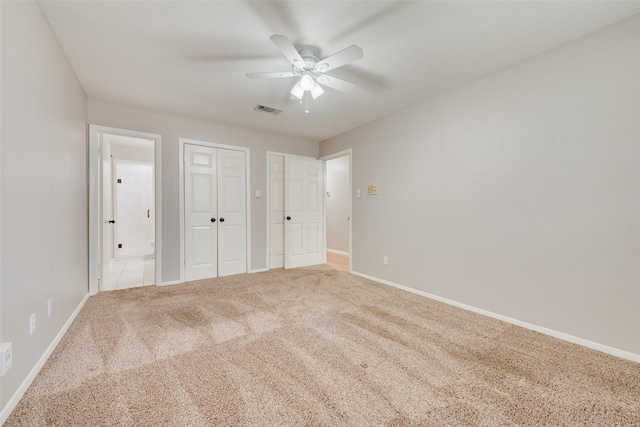 unfurnished bedroom featuring carpet floors, a ceiling fan, baseboards, and visible vents