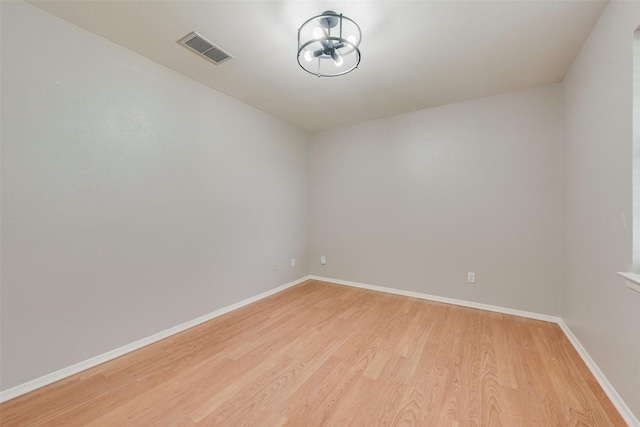 empty room featuring visible vents, baseboards, and light wood-type flooring