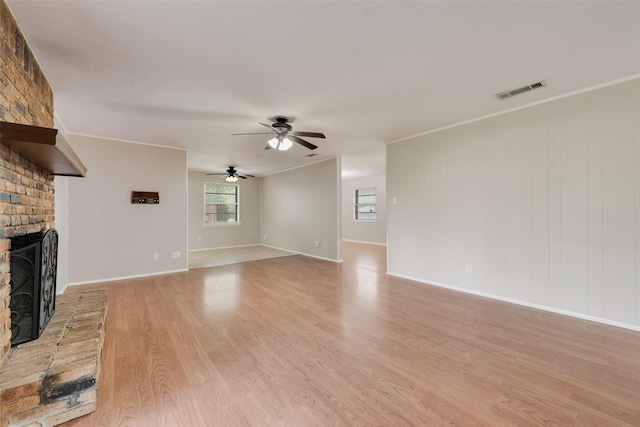 unfurnished living room featuring a fireplace, light wood-style flooring, a ceiling fan, baseboards, and visible vents
