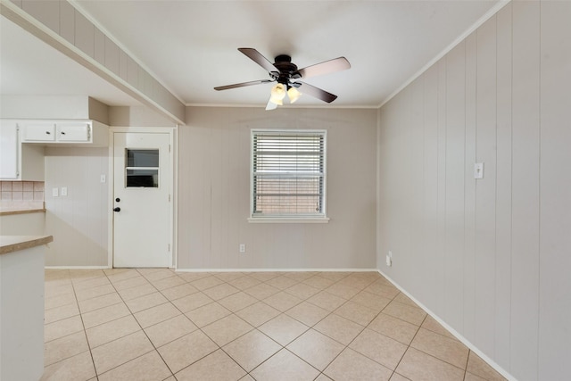 unfurnished room featuring crown molding, a ceiling fan, and light tile patterned flooring