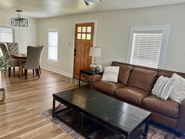 living room featuring baseboards, plenty of natural light, and light wood-type flooring