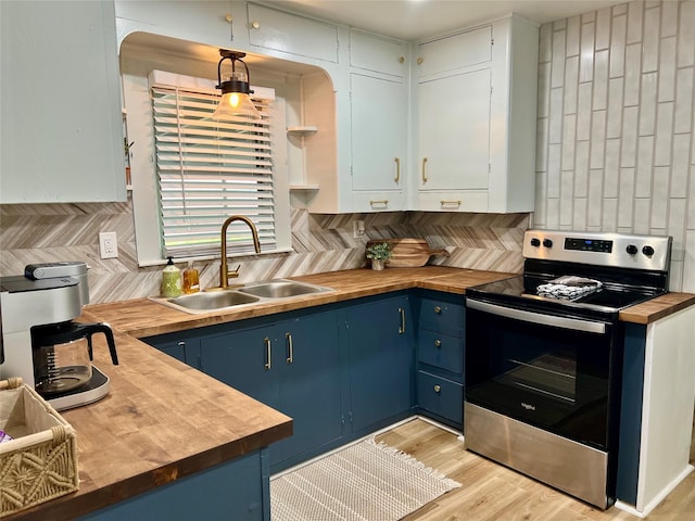kitchen featuring stainless steel electric range, blue cabinets, a sink, wood counters, and backsplash