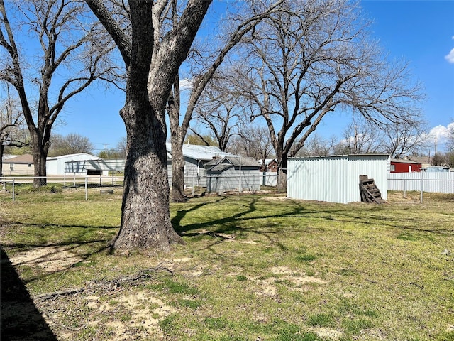view of yard with a pole building, fence, and an outdoor structure