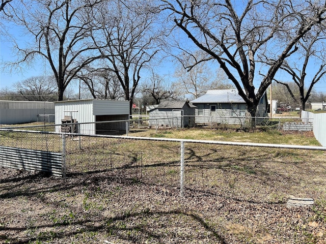 view of yard with a pole building, fence, and an outdoor structure
