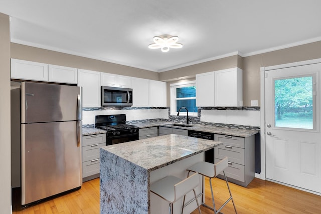 9528 Ash Creek Dr, Dallas, TX 75228 - kitchen featuring light stone counters, a sink, light wood-style flooring, a center island, and stainless steel appliances
