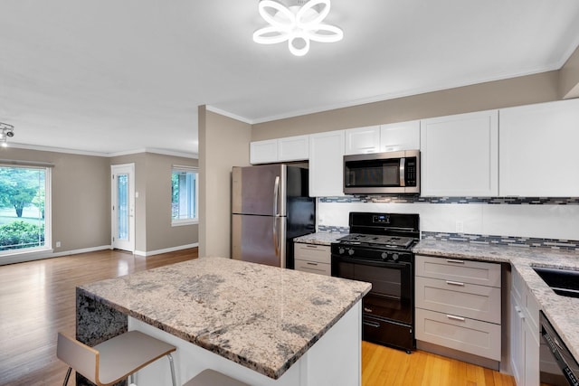 9528 Ash Creek Dr, Dallas, TX 75228 - kitchen featuring ornamental molding, light wood finished floors, black appliances, and a healthy amount of sunlight