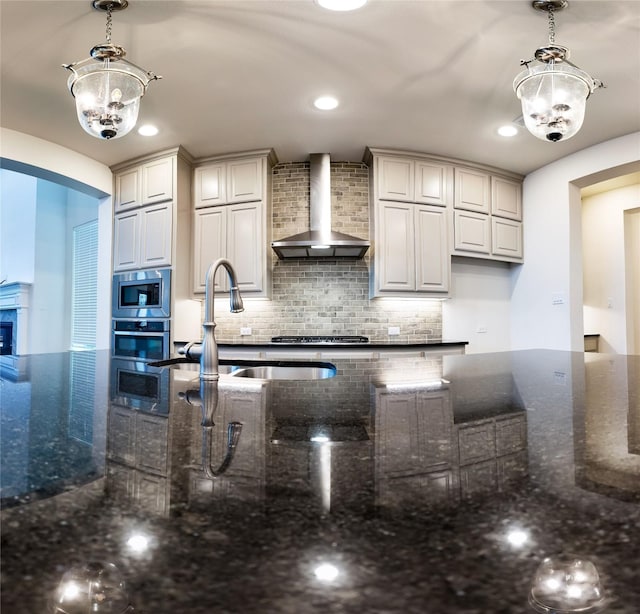 6900 Royal Liverpool Dr, Mckinney, TX 75070 - kitchen featuring wall chimney exhaust hood, tasteful backsplash, decorative light fixtures, and stainless steel appliances