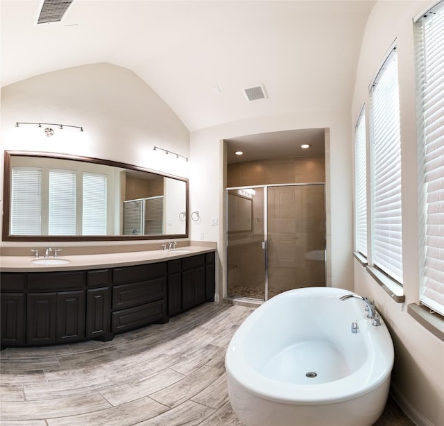 6900 Royal Liverpool Dr, Mckinney, TX 75070 - full bathroom with visible vents, a sink, a stall shower, and vaulted ceiling