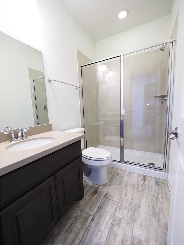 6900 Royal Liverpool Dr, Mckinney, TX 75070 - bathroom featuring vanity, a shower stall, toilet, and wood finished floors