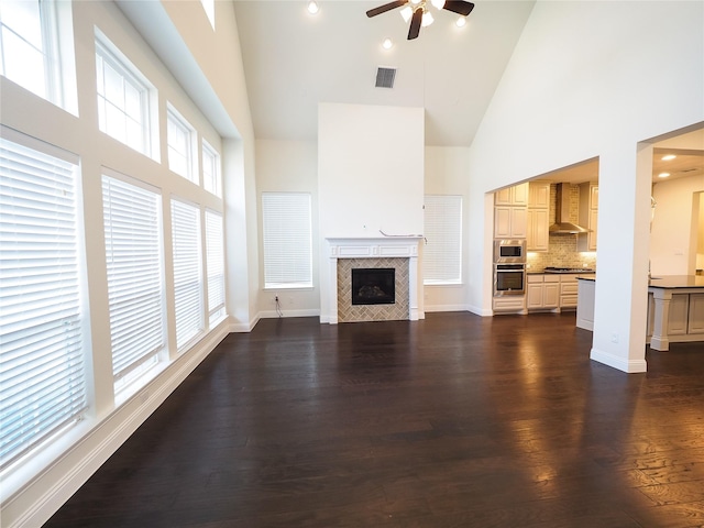 6900 Royal Liverpool Dr, Mckinney, TX 75070 - unfurnished living room featuring ceiling fan, visible vents, a fireplace, high vaulted ceiling, and dark wood-style floors