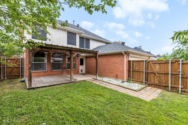 back of house featuring brick siding, a fenced backyard, a yard, and a gate