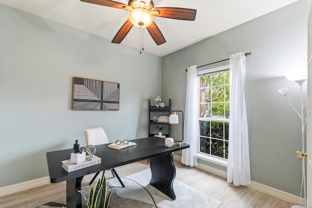 office area featuring a ceiling fan, baseboards, and light wood finished floors